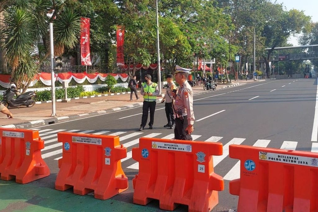 Sebagiam Personil Polisi Bediri Di Bagian Ruas Jalan Yang Di Tutup